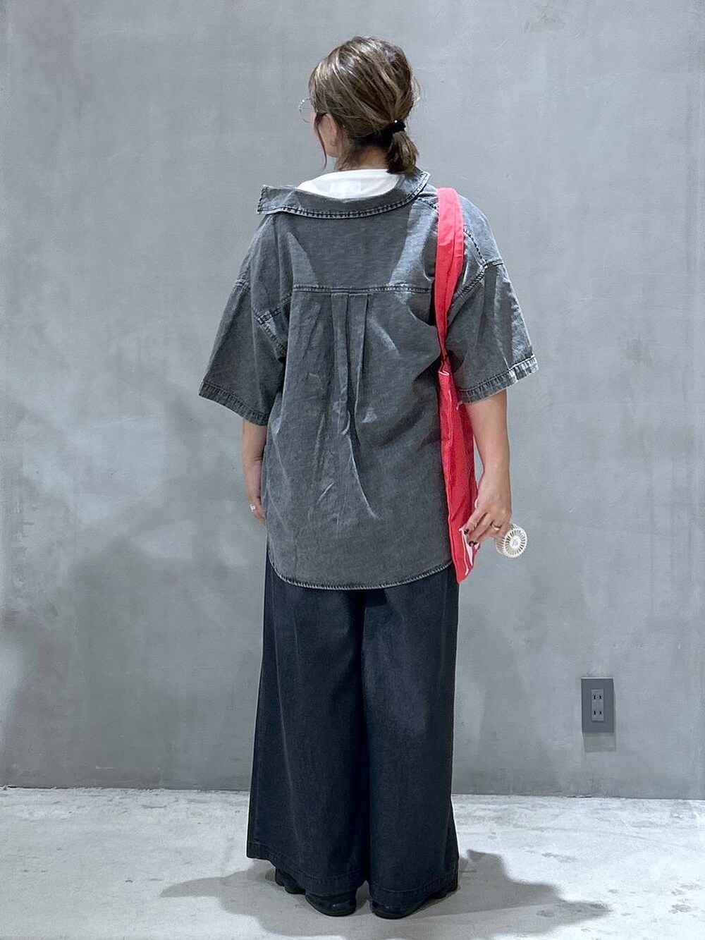 ブラック系のシャツ/ブラウス、レッド系のトートバッグ、ブラック系のデニムパンツを着用したレディースの夏コーディネートの2枚目の写真