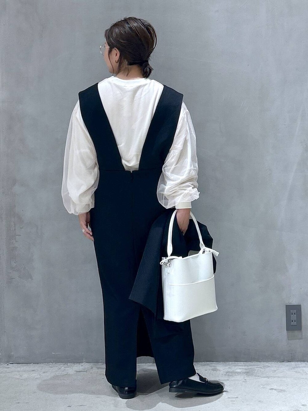 ブラック系のテーラードジャケット、ホワイト系のショルダーバッグ、ブラック系のローファーを着用したレディースの秋コーディネートの3枚目の写真