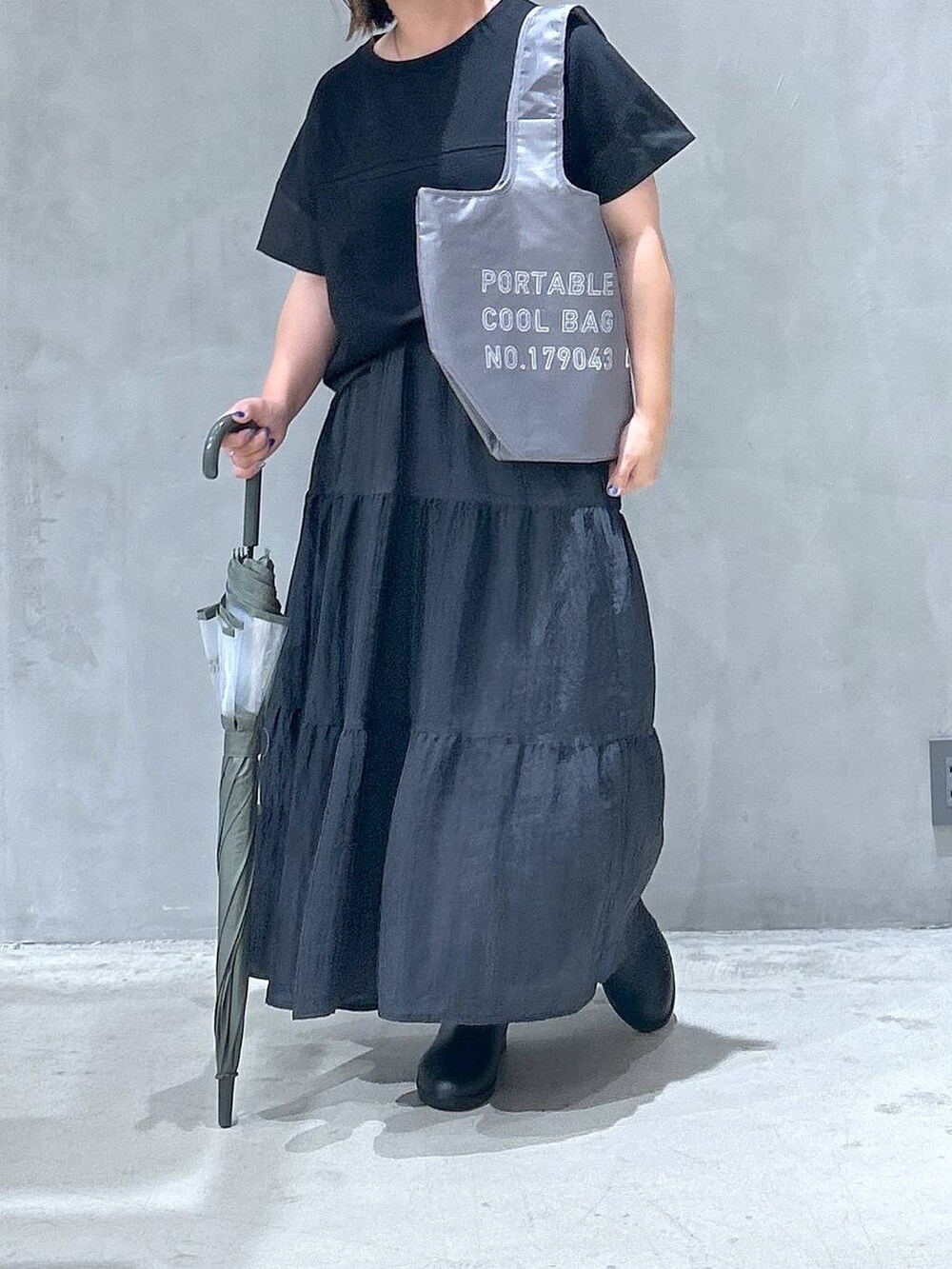ブラック系のレインシューズ、ブラック系のTシャツ/カットソー、ブラック系のスカートを着用したレディースの夏コーディネートの4枚目の写真