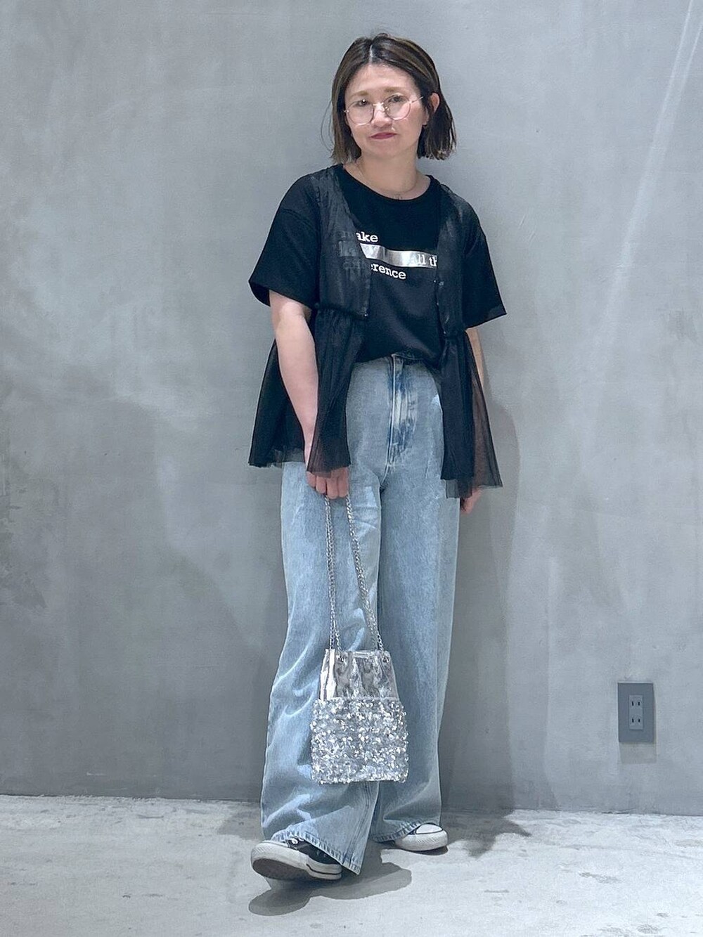 ブルー系のデニムパンツ、その他のショルダーバッグ、ブラック系のベストを着用したレディースの春コーディネートの5枚目の写真