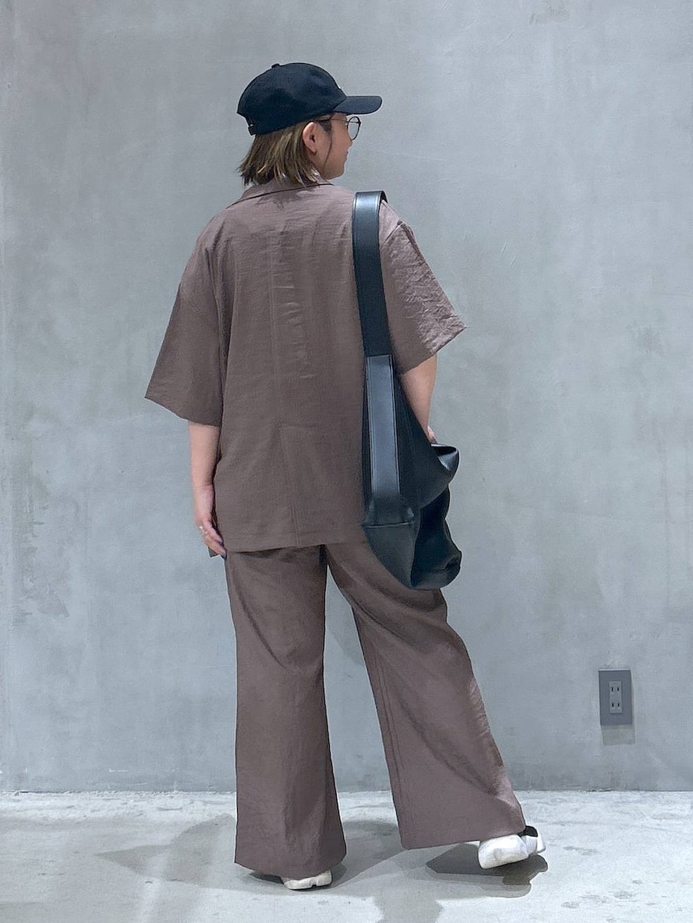 ブラック系のショルダーバッグ、ベージュ系のテーラードジャケット、ブラウン系のその他パンツを着用したレディースの夏コーディネートの2枚目の写真