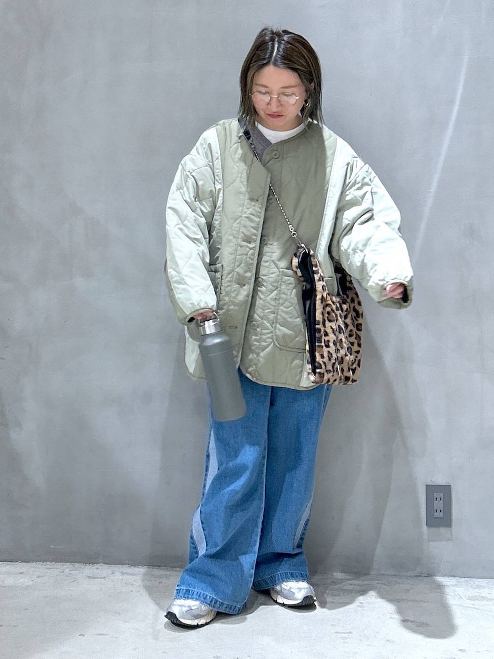 ブルー系のデニムパンツ、その他のショルダーバッグ、グリーン系のブルゾンを着用したレディースの秋コーディネートの5枚目の写真