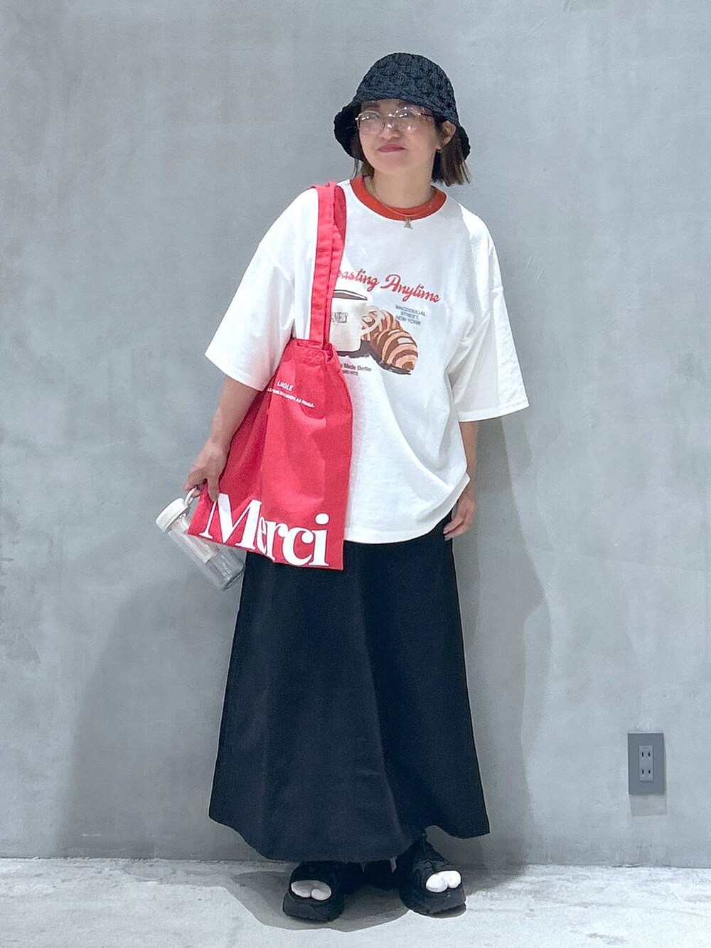 ブラック系のスニーカー、ブラック系のスカート、レッド系のTシャツ/カットソーを着用したレディースの春コーディネートの6枚目の写真