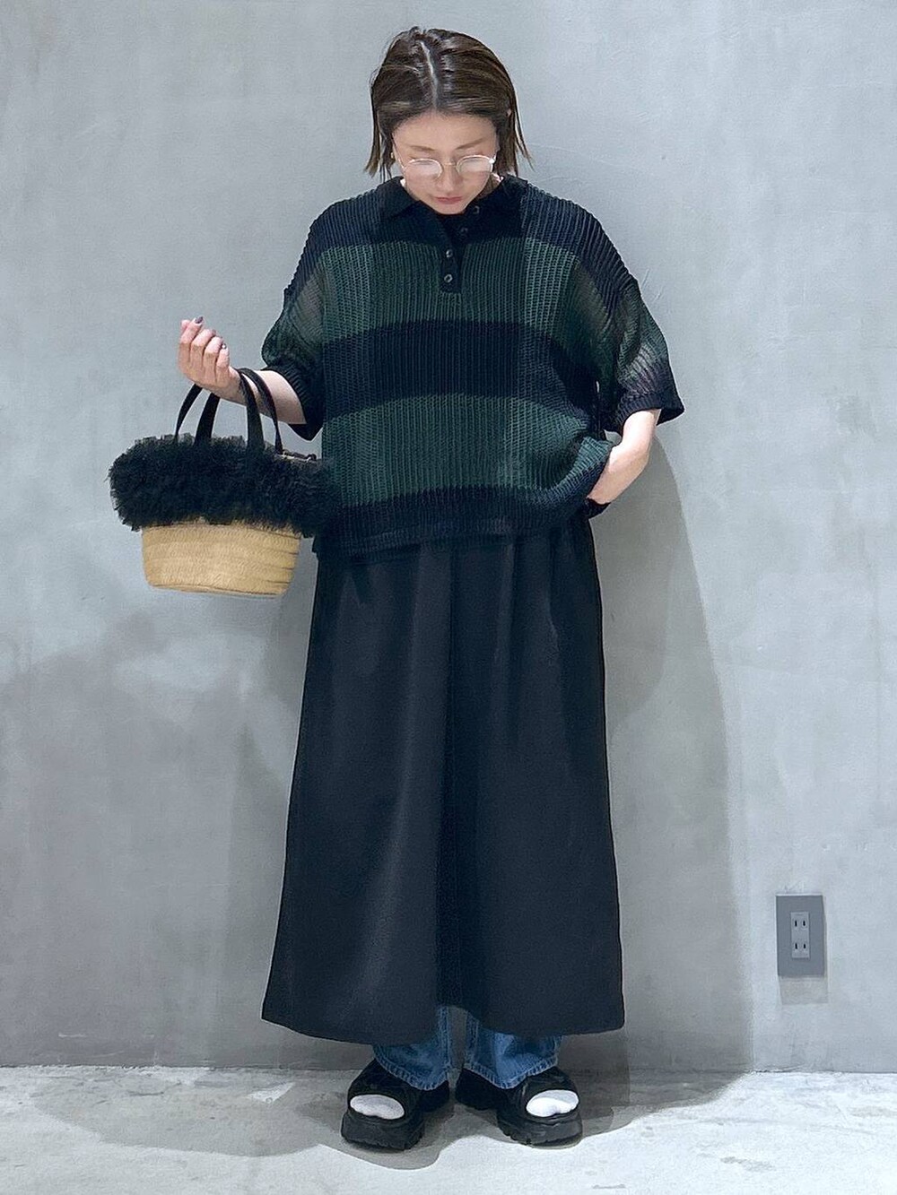 ブルー系のデニムパンツ、ベージュ系のショルダーバッグ、ブラック系のスニーカーを着用したレディースの春コーディネートの4枚目の写真