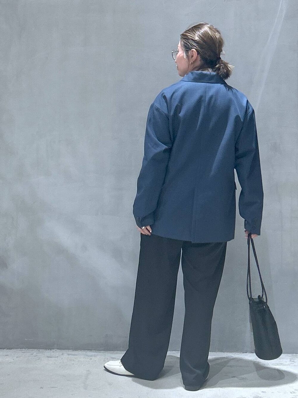 ベージュ系のTシャツ/カットソー、ブラック系のハンドバッグ、ベージュ系のローファーを着用したレディースの冬コーディネートの2枚目の写真