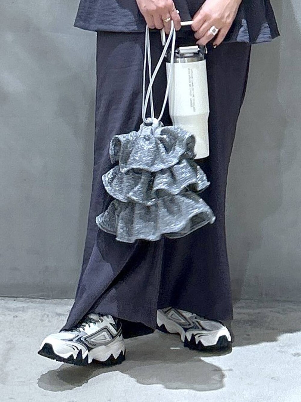 シルバー系のショルダーバッグ、ホワイト系のスニーカー、グレー系のその他パンツを着用したレディースの夏コーディネートの4枚目の写真