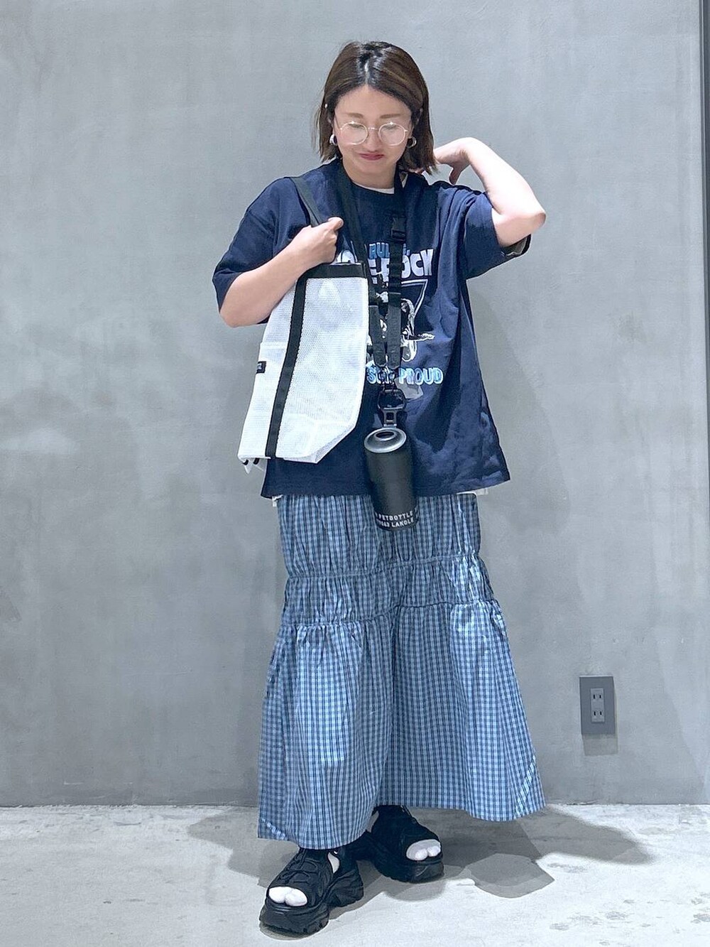 ブラック系のスニーカー、ホワイト系のTシャツ/カットソー、ブラック系のスマホグッズを着用したレディースの春コーディネートの5枚目の写真