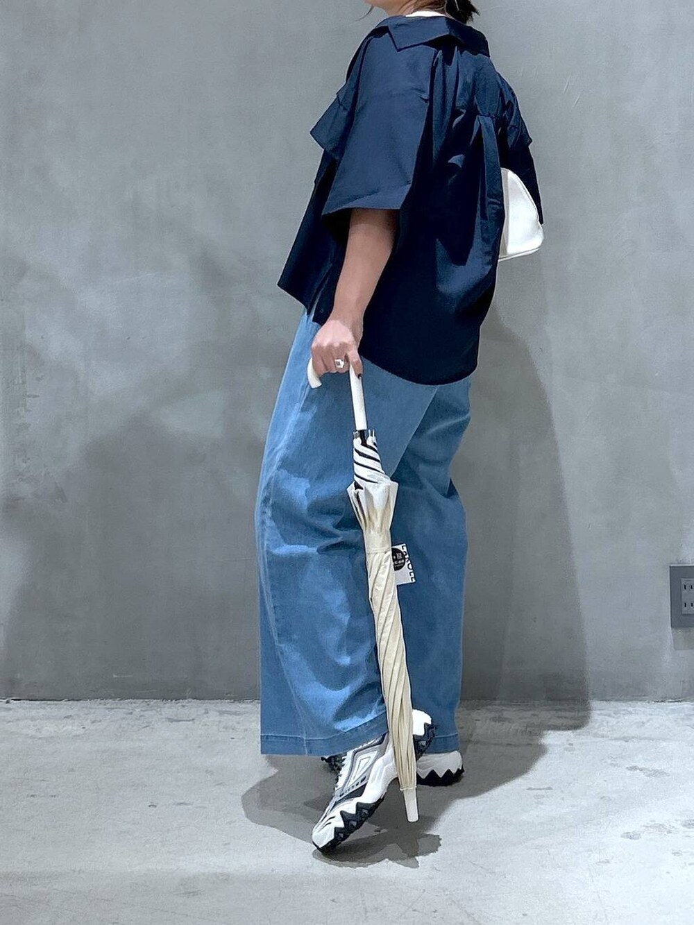 ホワイト系のスニーカー、ホワイト系のボストンバッグ、ブルー系のシャツ/ブラウスを着用したレディースの夏コーディネートの3枚目の写真