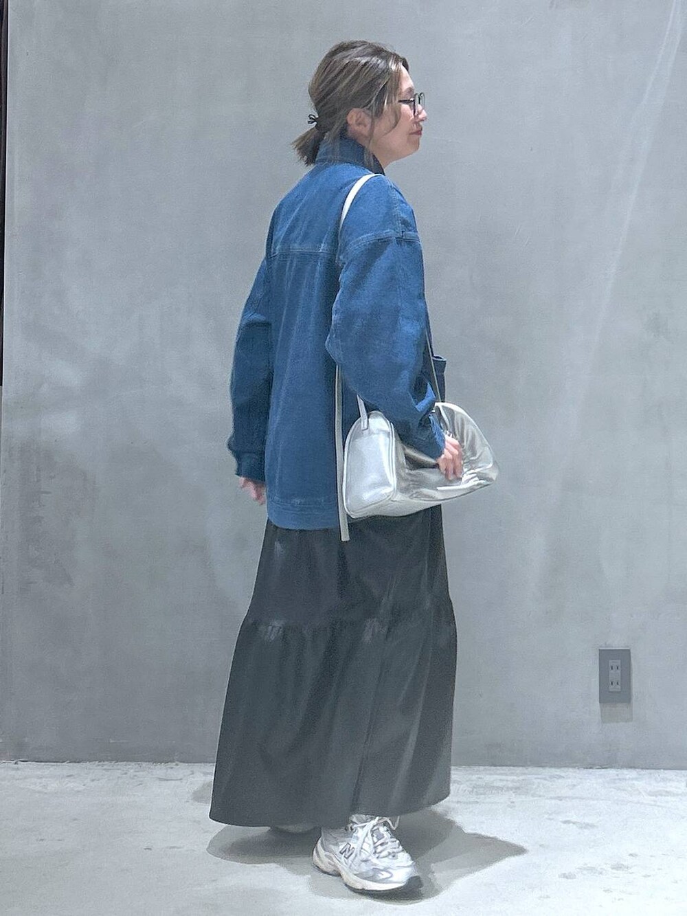 ブラック系のワンピース、シルバー系のショルダーバッグ、ブルー系のデニムジャケットを着用したレディースの冬コーディネートの2枚目の写真