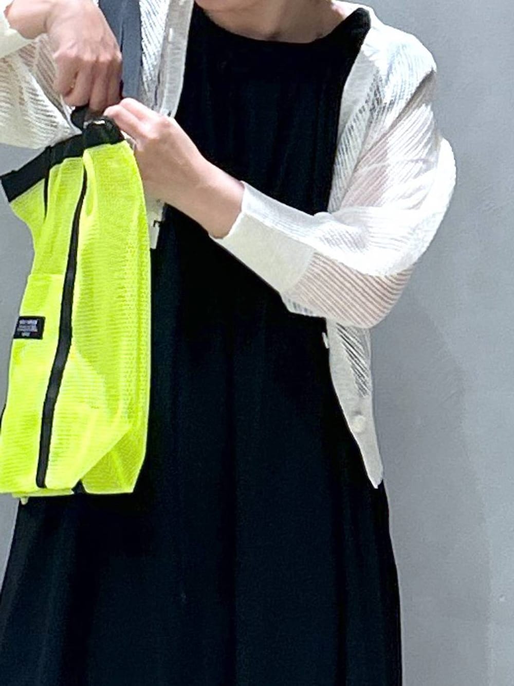 ブルー系のデニムパンツ、ブラック系のスニーカー、ホワイト系のカーディガン/ボレロを着用したレディースの春コーディネートの6枚目の写真