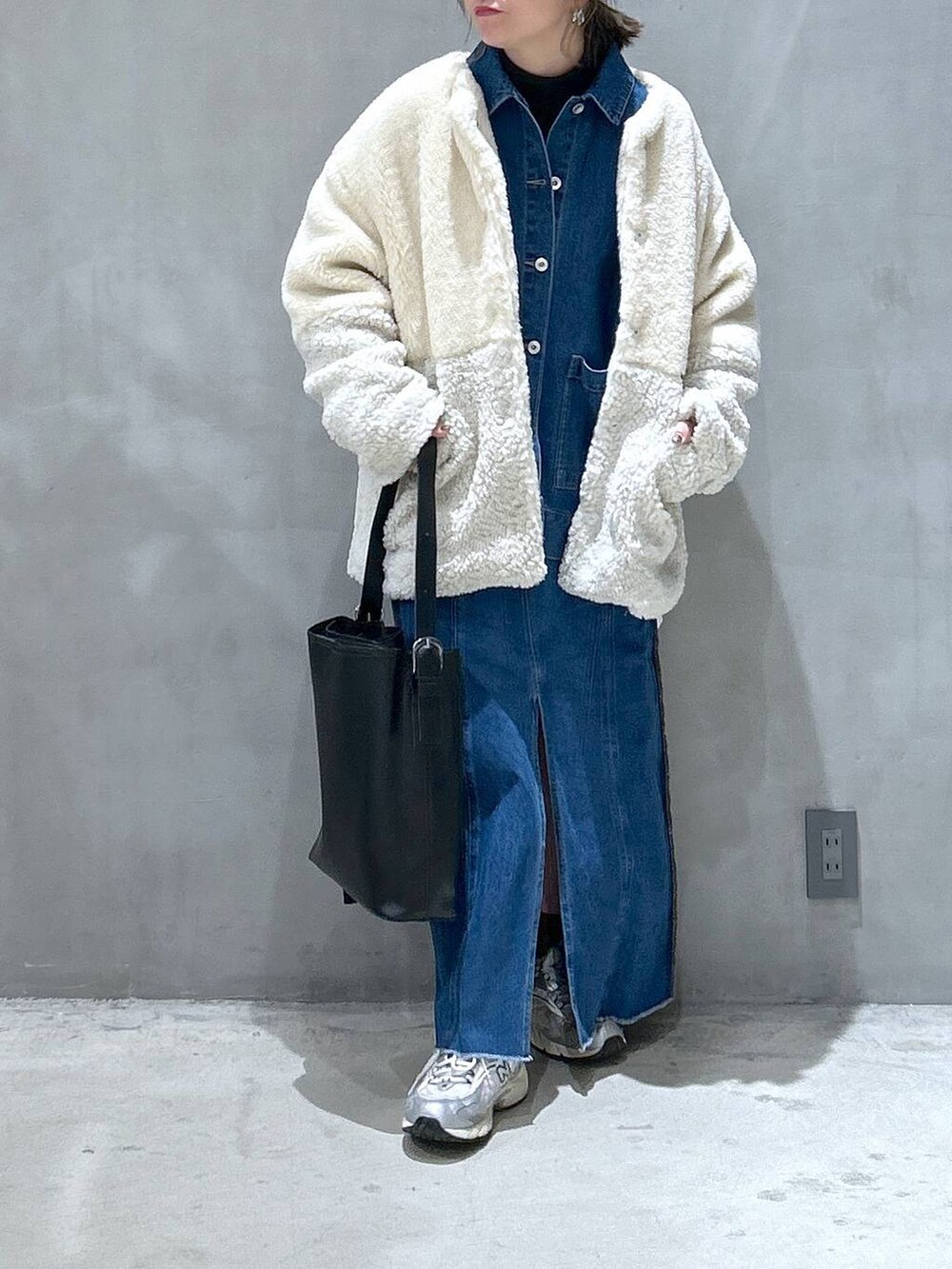 ベージュ系のブルゾン、ブルー系のデニムスカート、ブラック系のショルダーバッグを着用したレディースの冬コーディネートの5枚目の写真