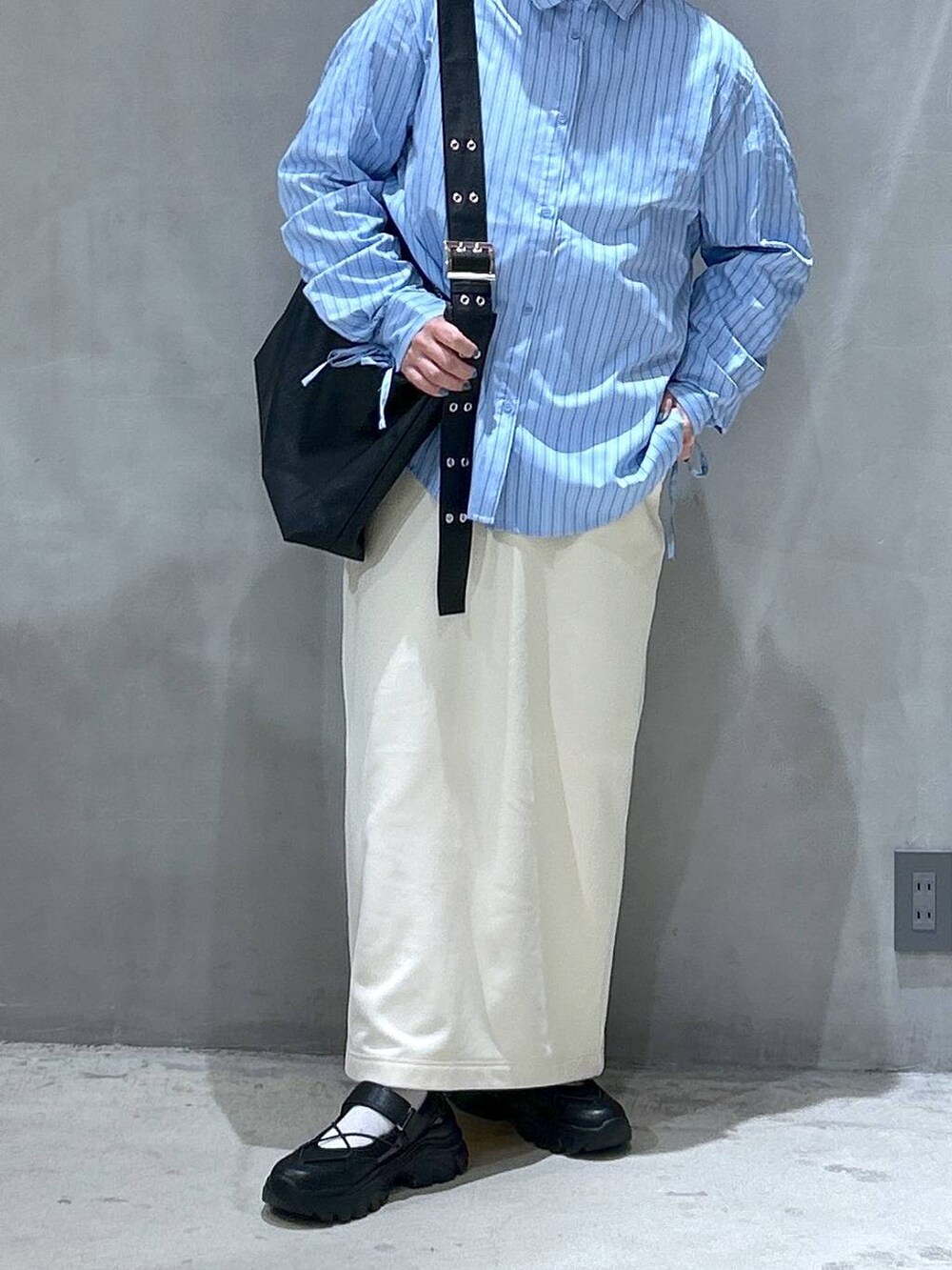 ホワイト系のスカート、ブラック系のスニーカー、ブラック系のショルダーバッグを着用したレディースの春コーディネートの6枚目の写真