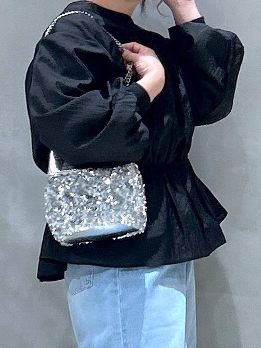 ブルー系のデニムパンツ、ブラック系のスウェット、その他のショルダーバッグを着用したレディースの冬コーディネートの5枚目の写真