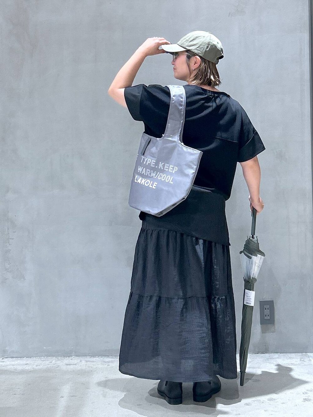 ブラック系のレインシューズ、ブラック系のTシャツ/カットソー、ブラック系のスカートを着用したレディースの夏コーディネートの2枚目の写真