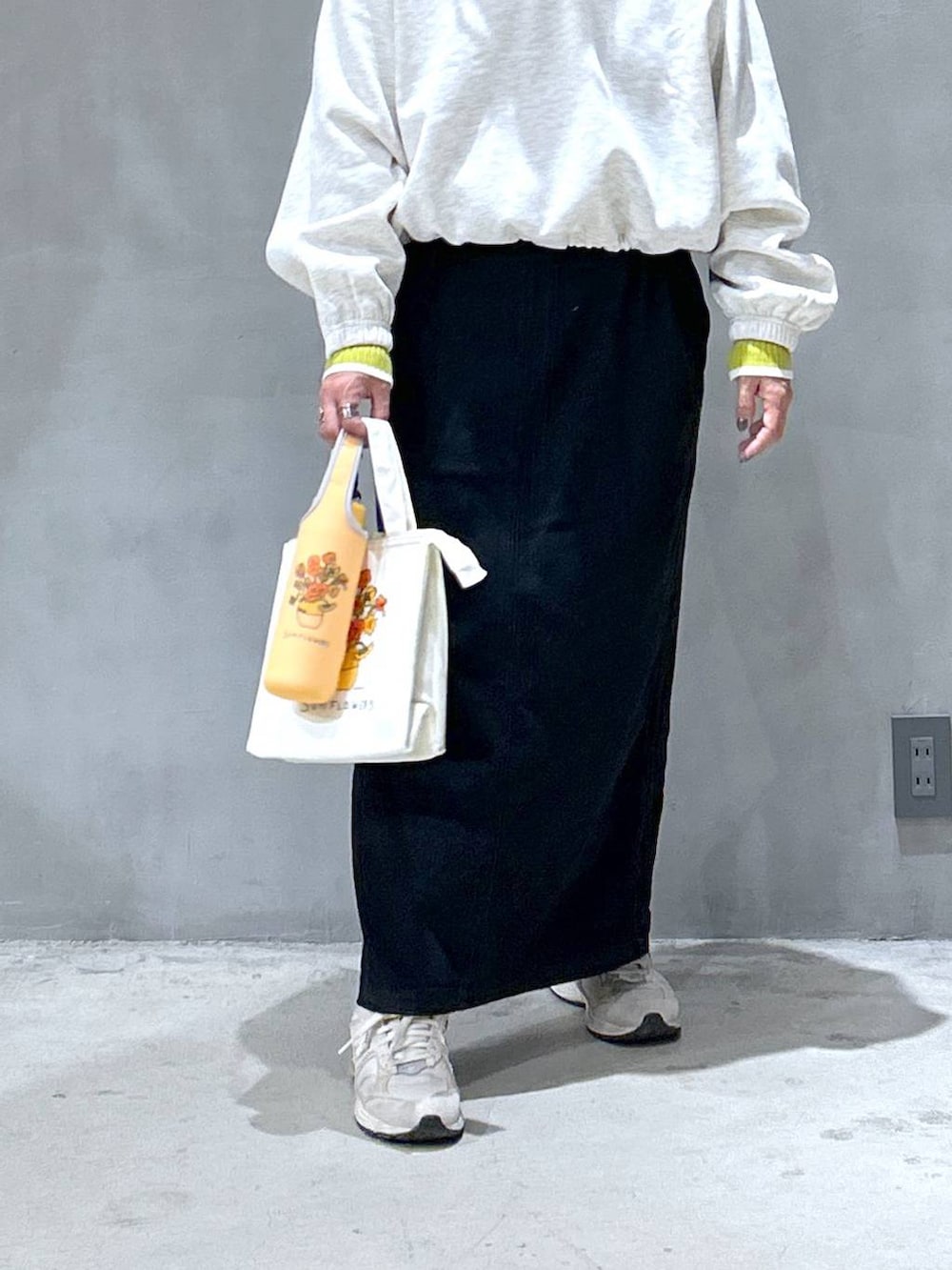 グレー系のジャンパースカート、ベージュ系のスウェット、グリーン系のニット/セーターを着用したレディースの秋コーディネートの4枚目の写真