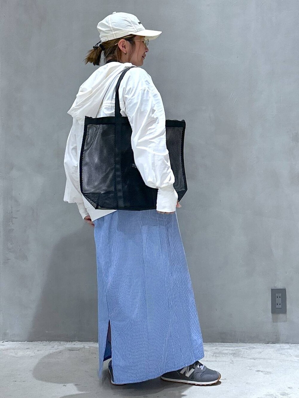 グレー系のスニーカー、グレー系のTシャツ/カットソー、ブルー系のワンピースを着用したレディースの春コーディネートの4枚目の写真