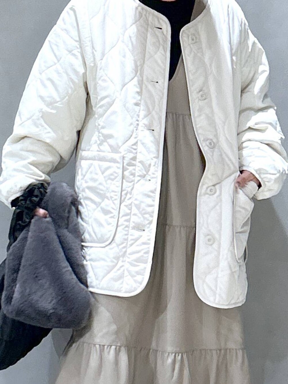 ブラック系のニット/セーター、ベージュ系のブルゾン、ブラック系のブーツを着用したレディースの秋コーディネートの3枚目の写真