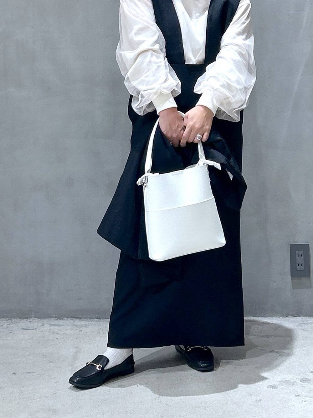 ブラック系のテーラードジャケット、ホワイト系のショルダーバッグ、ブラック系のローファーを着用したレディースの秋コーディネートの5枚目の写真