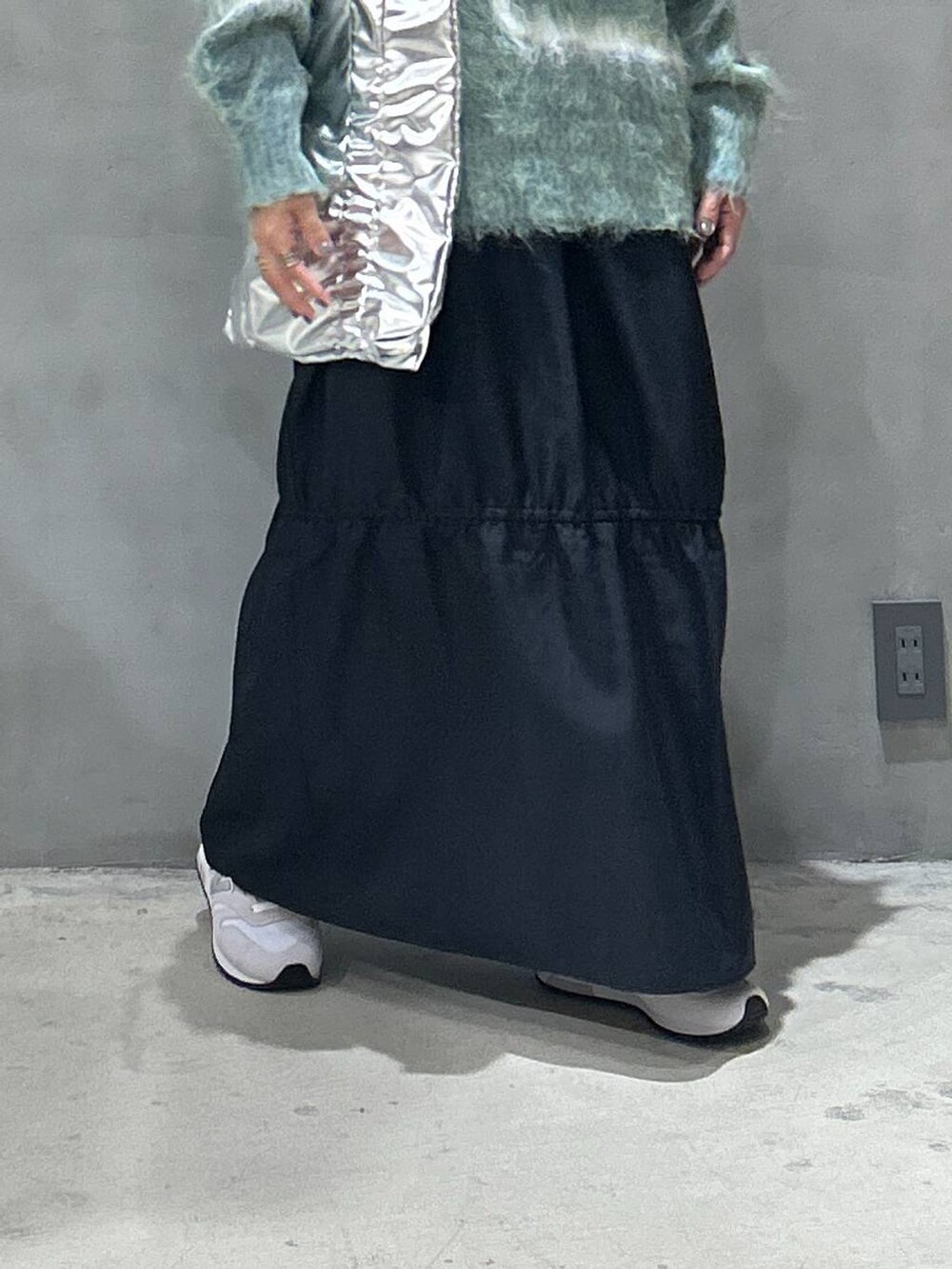 ホワイト系のスニーカー、グリーン系のニット/セーター、シルバー系のトートバッグを着用したレディースの秋コーディネートの3枚目の写真