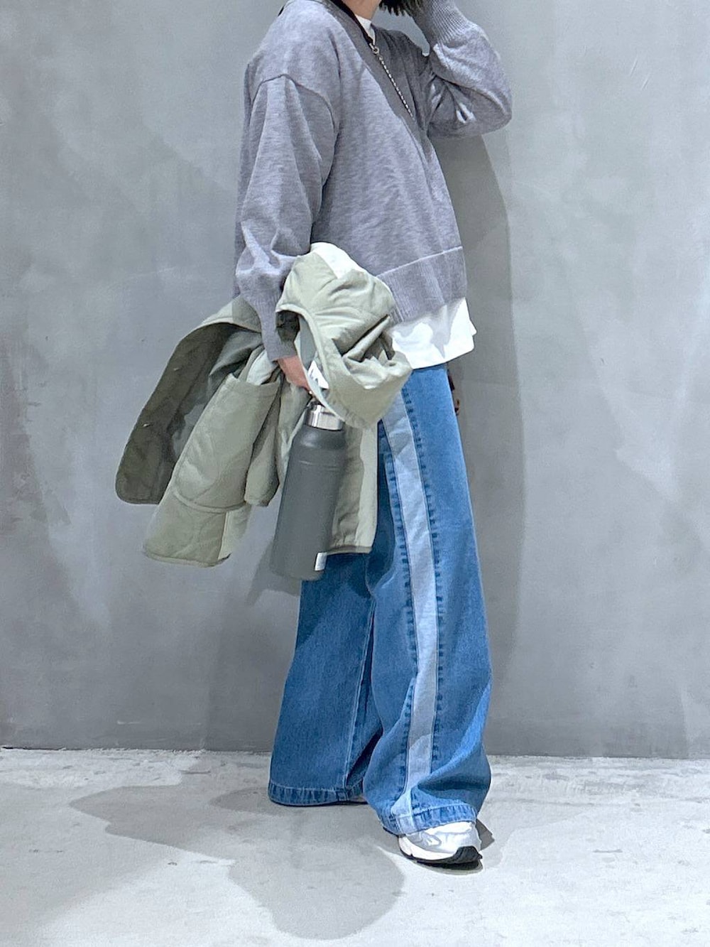 ブルー系のデニムパンツ、その他のショルダーバッグ、グリーン系のブルゾンを着用したレディースの秋コーディネートの6枚目の写真