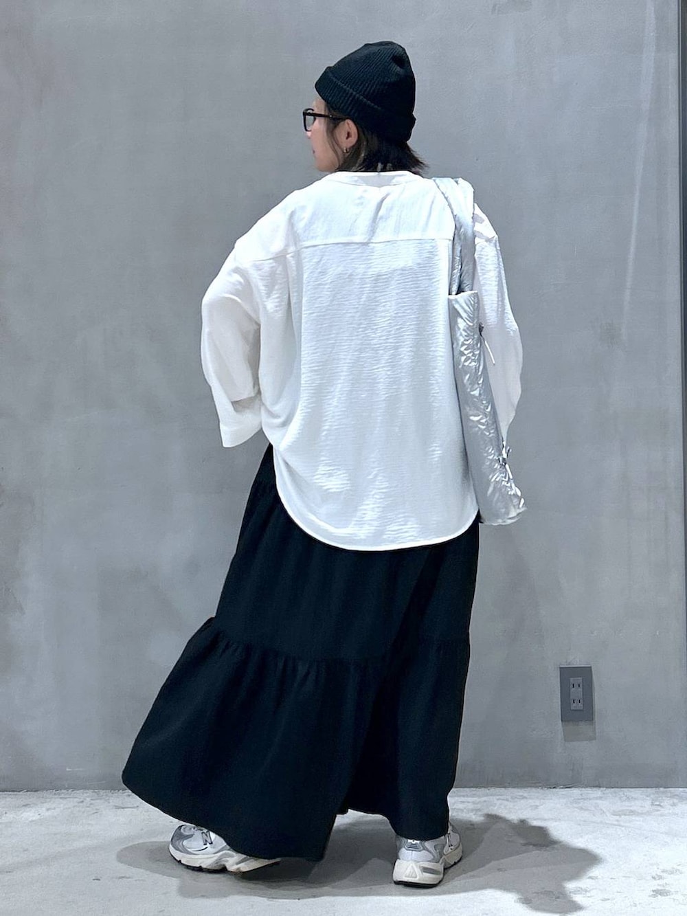 グレー系のスニーカー、ブラック系のワンピース、ホワイト系のシャツ/ブラウスを着用したレディースの秋コーディネートの2枚目の写真