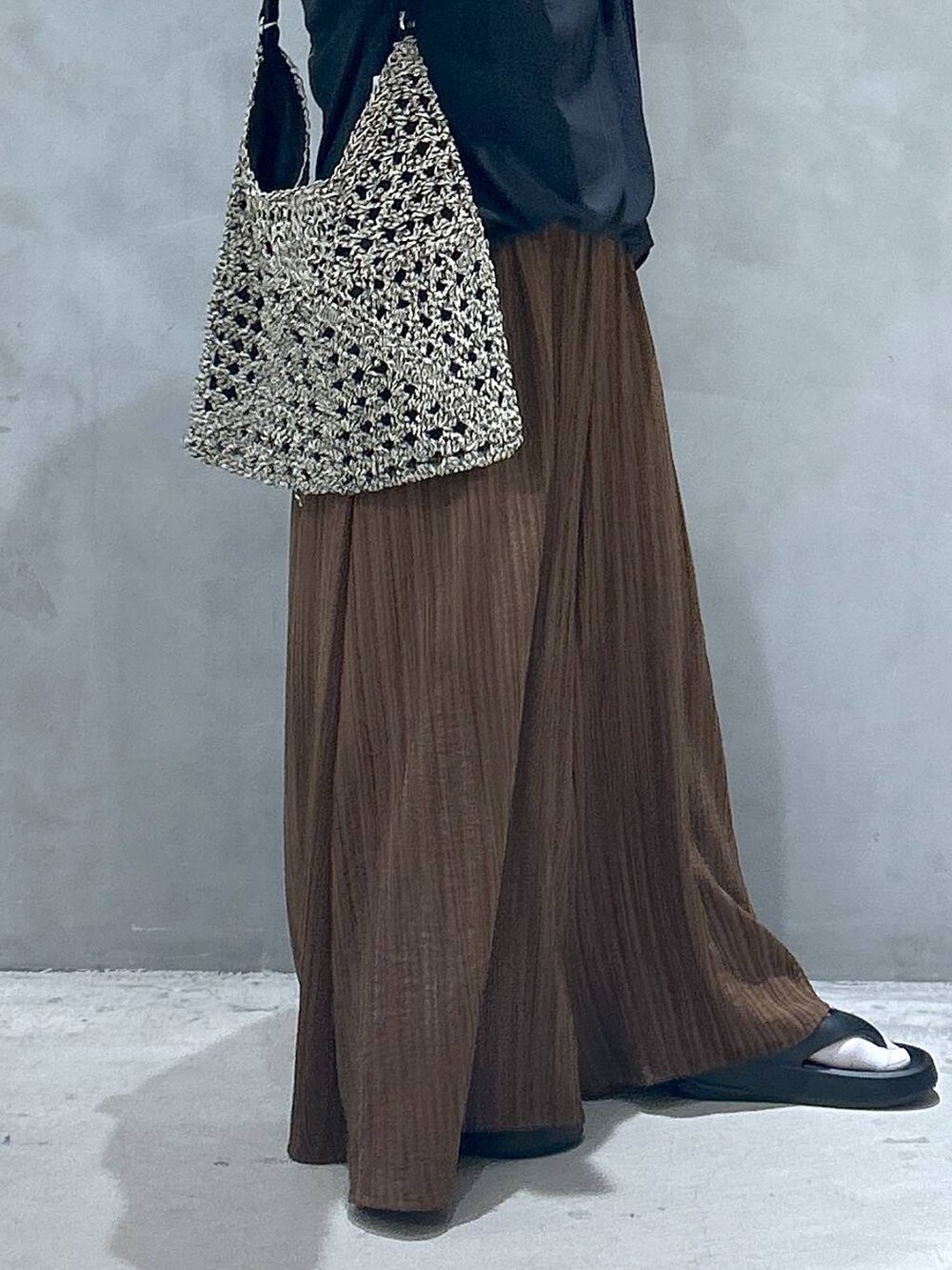 ブラック系のトートバッグ、ブラック系のサンダル、ブラウン系のその他パンツを着用したレディースの春コーディネートの3枚目の写真