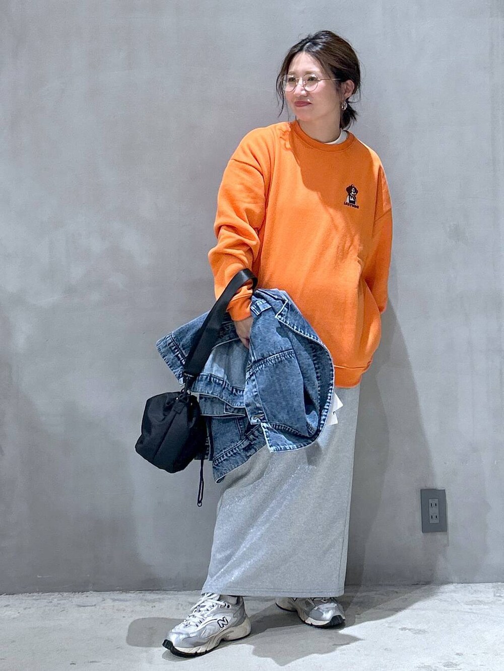 グレー系のスニーカー、ブラック系のショルダーバッグ、ブルー系のデニムジャケットを着用したレディースの秋コーディネートの5枚目の写真