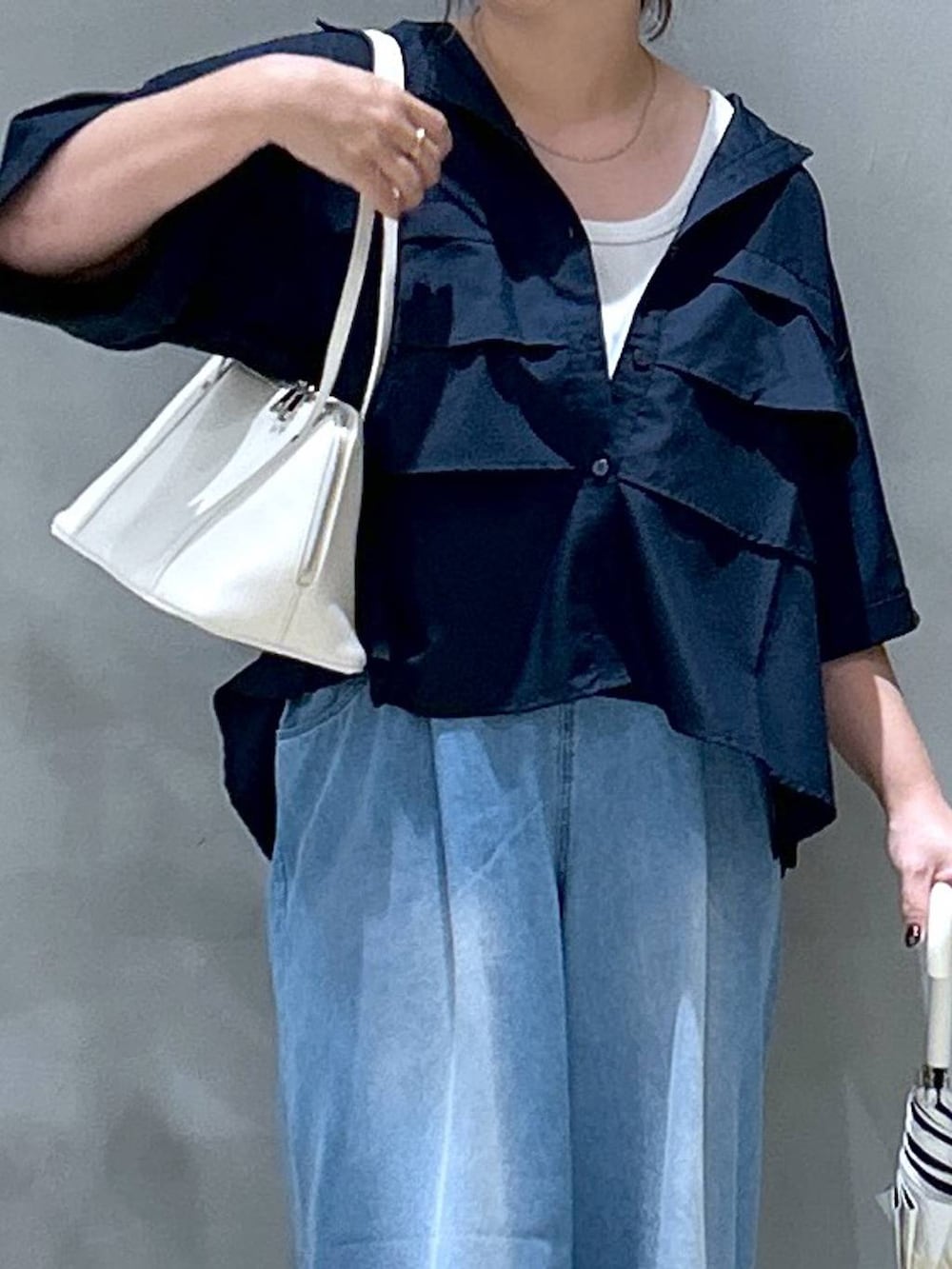 ホワイト系のスニーカー、ホワイト系のボストンバッグ、ブルー系のシャツ/ブラウスを着用したレディースの夏コーディネートの2枚目の写真