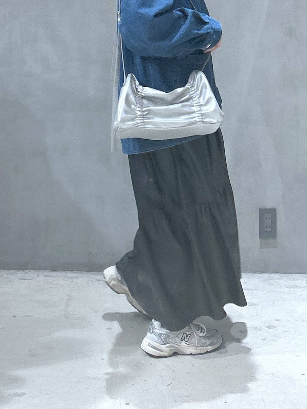 ブラック系のワンピース、シルバー系のショルダーバッグ、ブルー系のデニムジャケットを着用したレディースの冬コーディネートの4枚目の写真