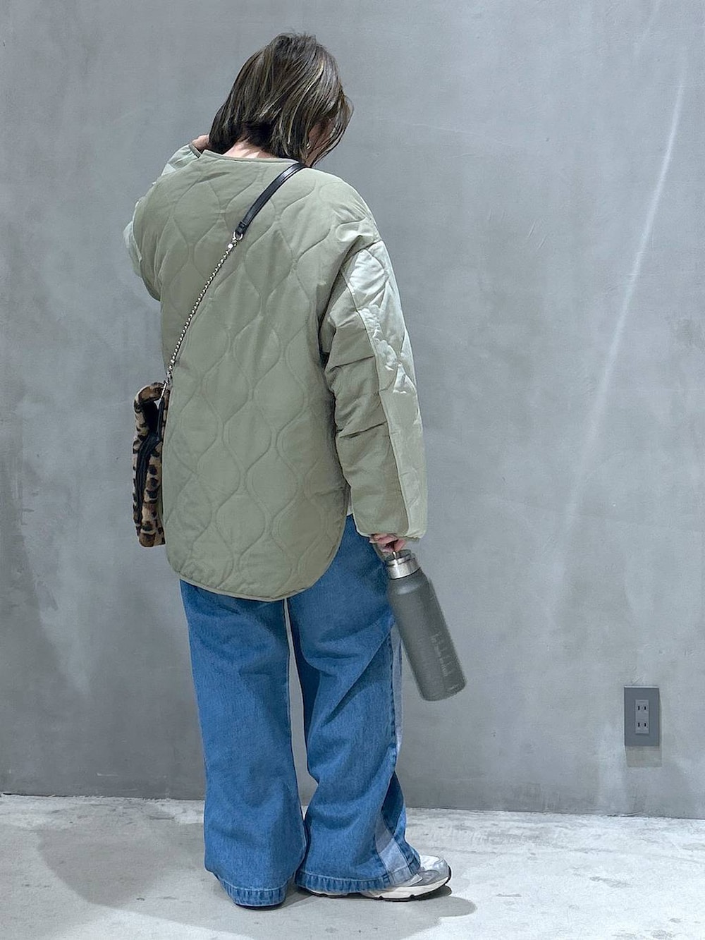 ブルー系のデニムパンツ、その他のショルダーバッグ、グリーン系のブルゾンを着用したレディースの秋コーディネートの2枚目の写真