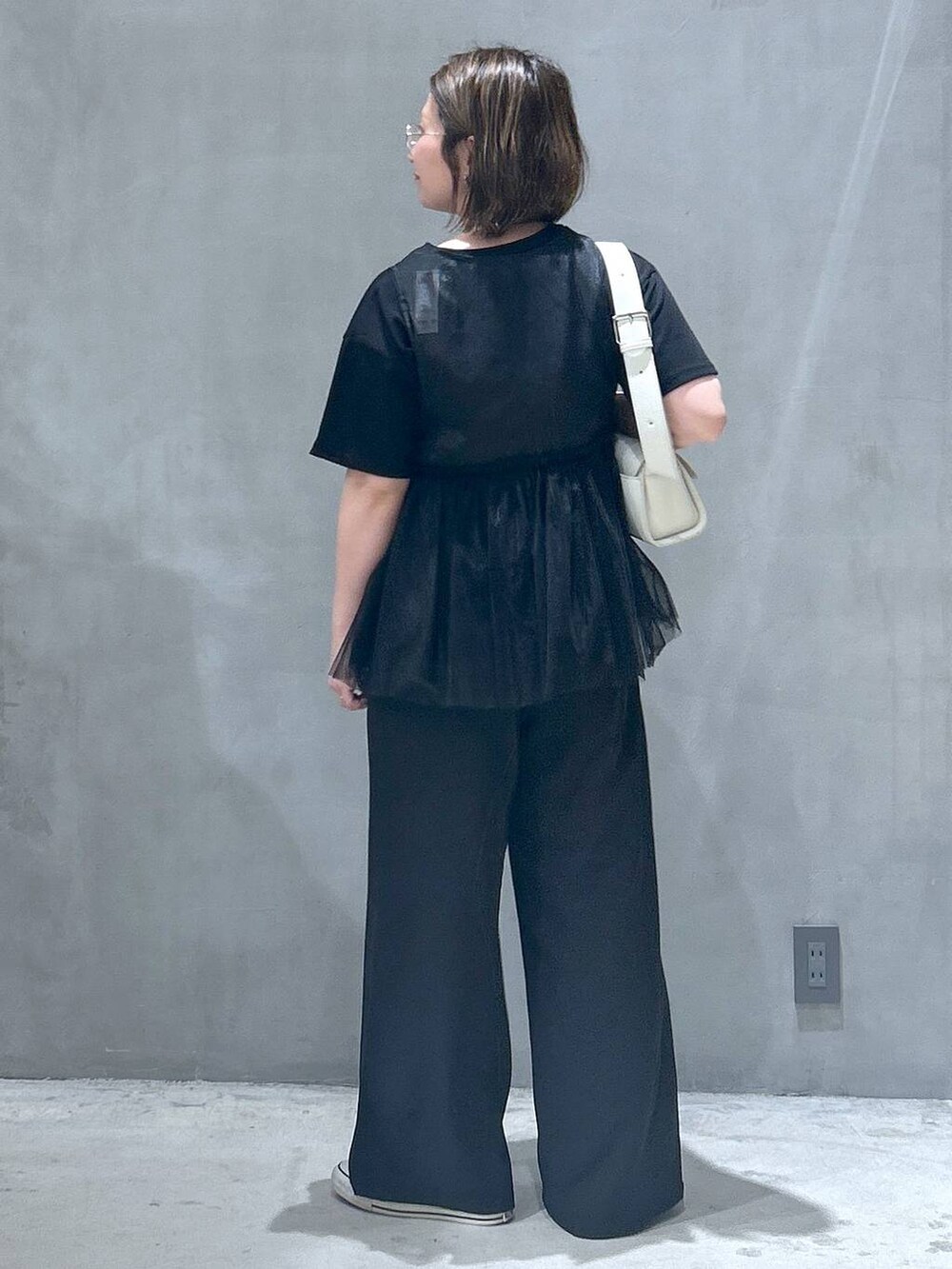 ブラック系のその他パンツ、ホワイト系のショルダーバッグ、ブラック系のベストを着用したレディースの春コーディネートの2枚目の写真