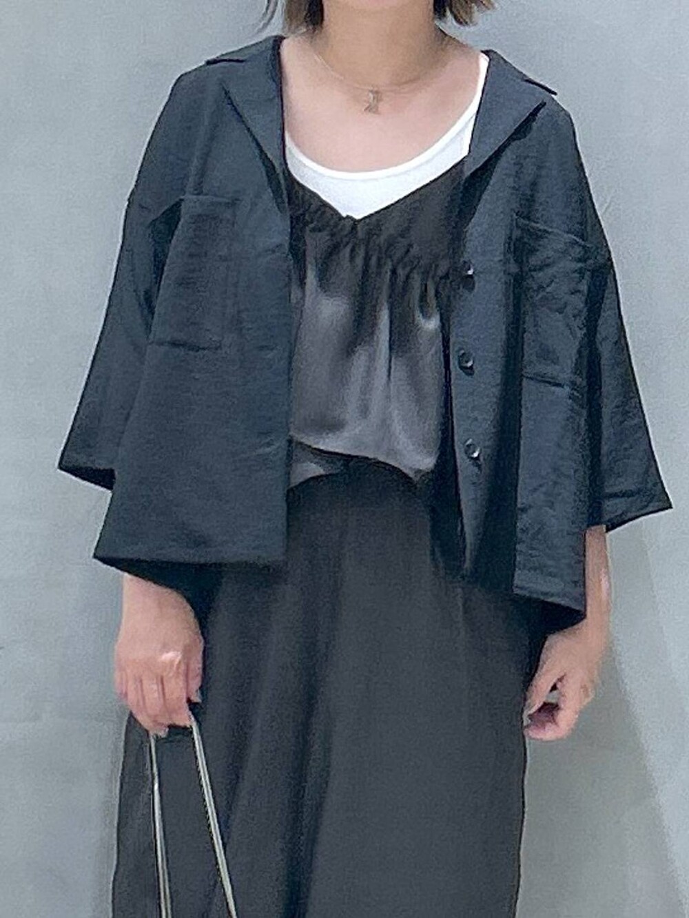 ブラック系のスニーカー、ホワイト系のタンクトップ、ブラック系のショルダーバッグを着用したレディースの春コーディネートの3枚目の写真