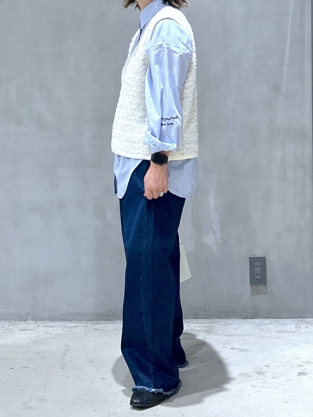 ブルー系のデニムパンツ、ブルー系のシャツ/ブラウス、ホワイト系のショルダーバッグを着用したレディースの秋コーディネートの5枚目の写真