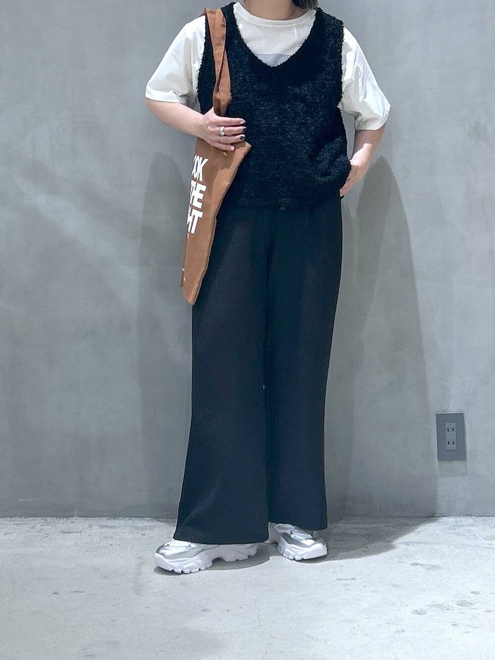 ブラック系のその他パンツ、シルバー系のスニーカー、ブラック系のベストを着用したレディースの春コーディネートの5枚目の写真