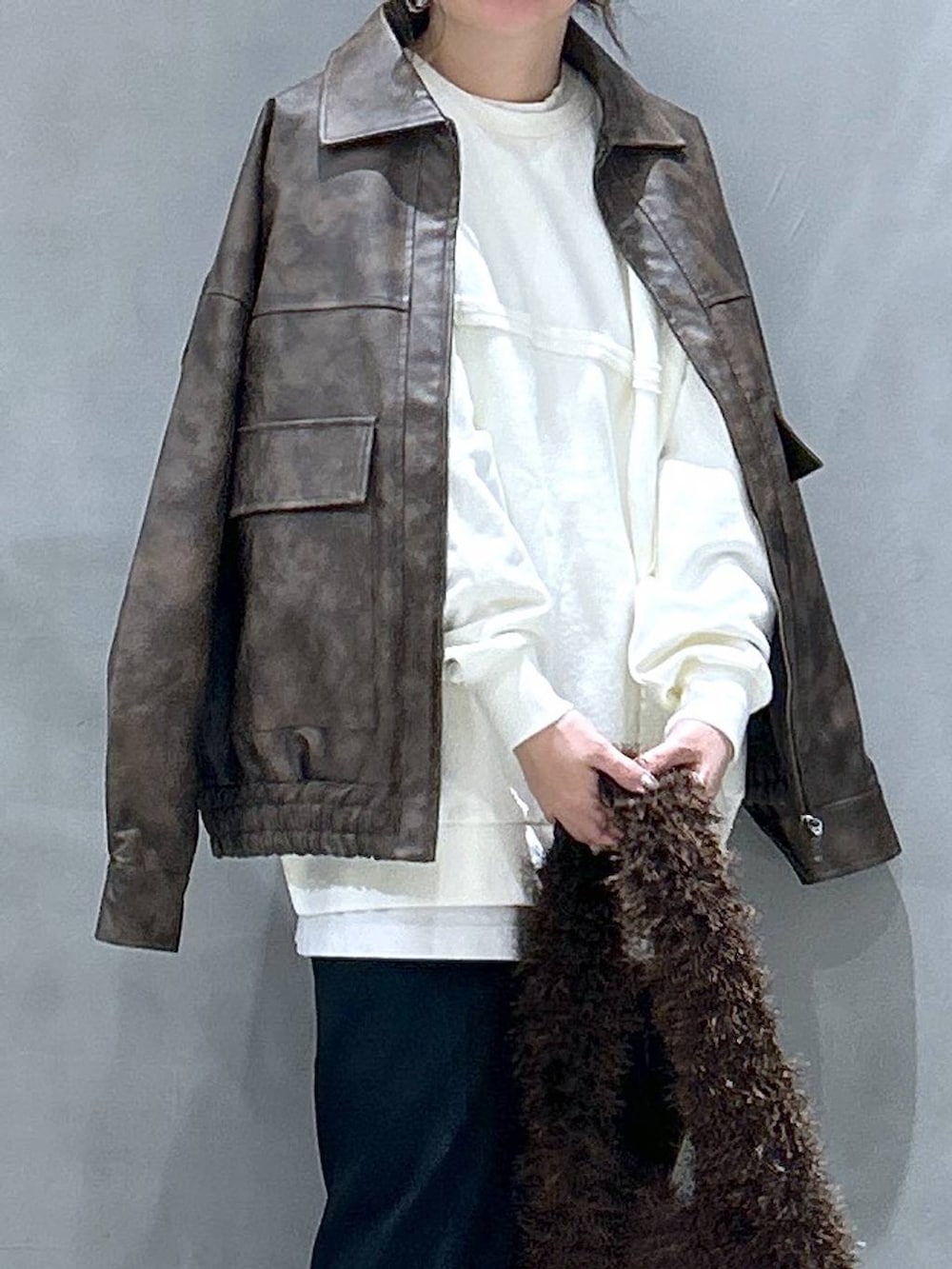 グレー系のスニーカー、ブラウン系のブルゾン、ブラウン系のショルダーバッグを着用したレディースの冬コーディネートの3枚目の写真