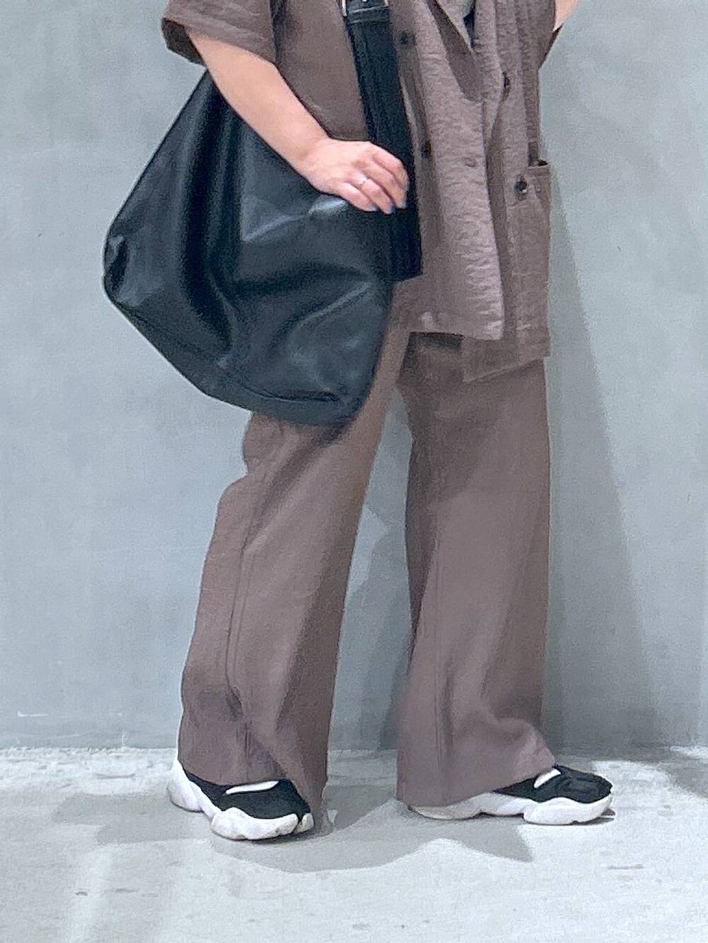 ブラック系のショルダーバッグ、ベージュ系のテーラードジャケット、ブラウン系のその他パンツを着用したレディースの夏コーディネートの5枚目の写真