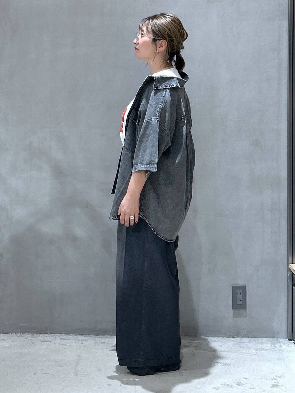 ブラック系のシャツ/ブラウス、レッド系のトートバッグ、ブラック系のデニムパンツを着用したレディースの夏コーディネートの3枚目の写真