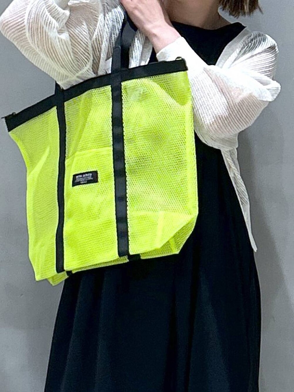 ブルー系のデニムパンツ、ブラック系のスニーカー、ホワイト系のカーディガン/ボレロを着用したレディースの春コーディネートの3枚目の写真