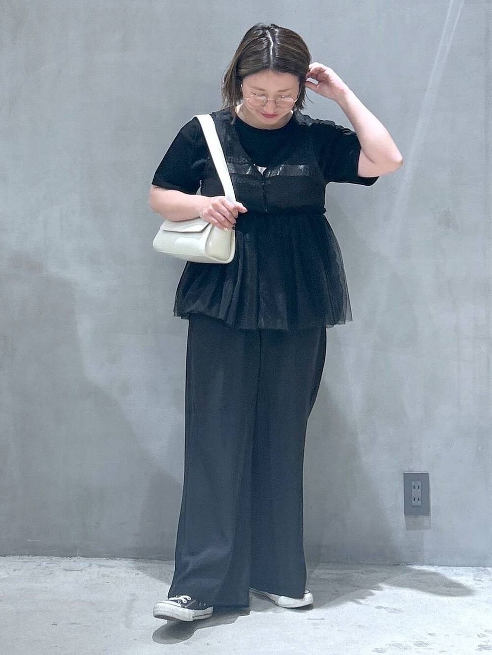 ブラック系のその他パンツ、ホワイト系のショルダーバッグ、ブラック系のベストを着用したレディースの春コーディネートの5枚目の写真