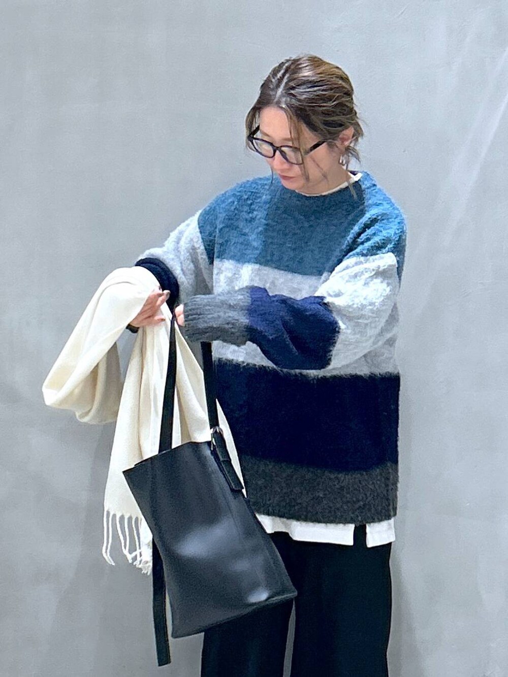 グレー系のスニーカー、ブラック系のその他パンツ、ブルー系のニット/セーターを着用したレディースの冬コーディネートの3枚目の写真