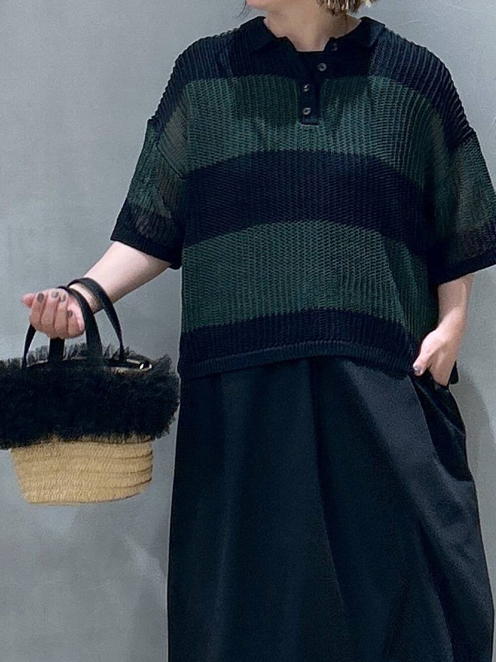 ブルー系のデニムパンツ、ベージュ系のショルダーバッグ、ブラック系のスニーカーを着用したレディースの春コーディネートの3枚目の写真