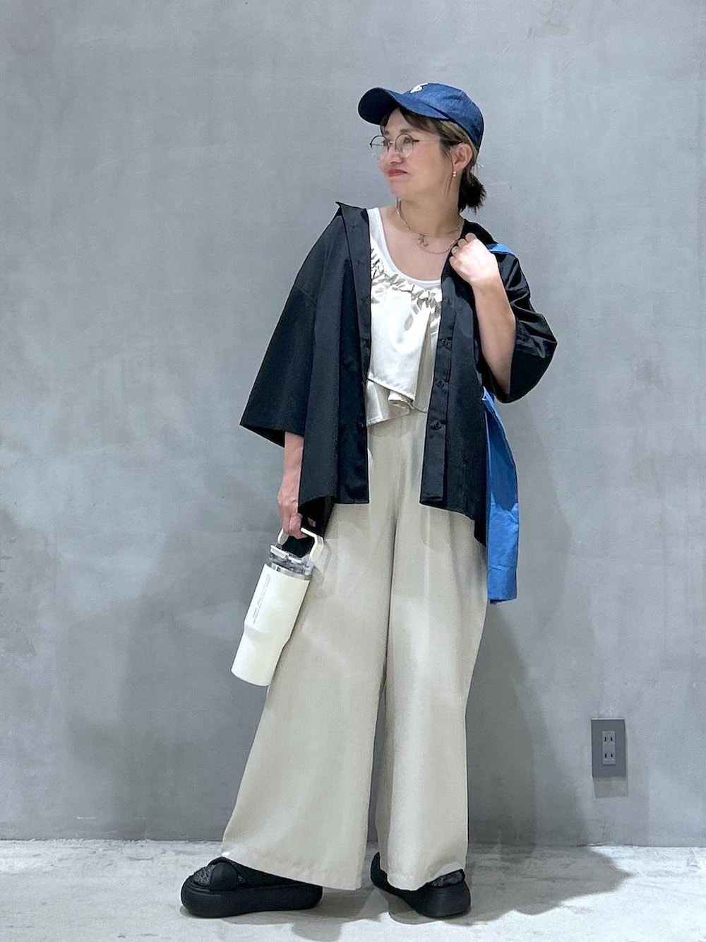 ブラック系のサンダル、ブルー系のトートバッグ、ベージュ系のつなぎ/オールインワンを着用したレディースの夏コーディネートの5枚目の写真