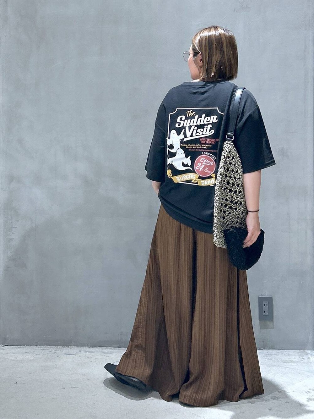 ブラック系のトートバッグ、ブラック系のサンダル、ブラウン系のその他パンツを着用したレディースの春コーディネートの2枚目の写真