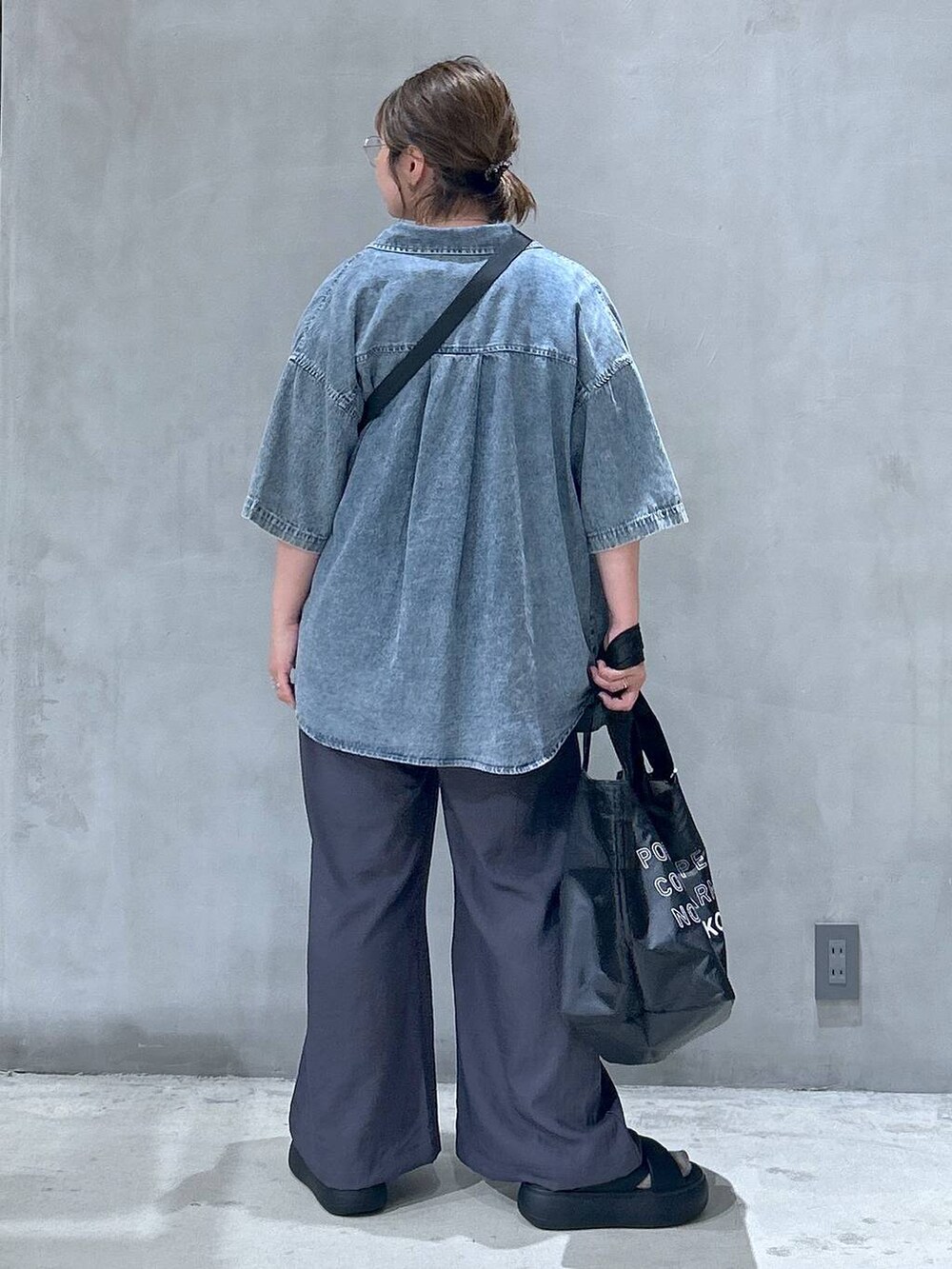 ブラック系のショルダーバッグ、ブラック系のサンダル、ブルー系のシャツ/ブラウスを着用したレディースの夏コーディネートの2枚目の写真