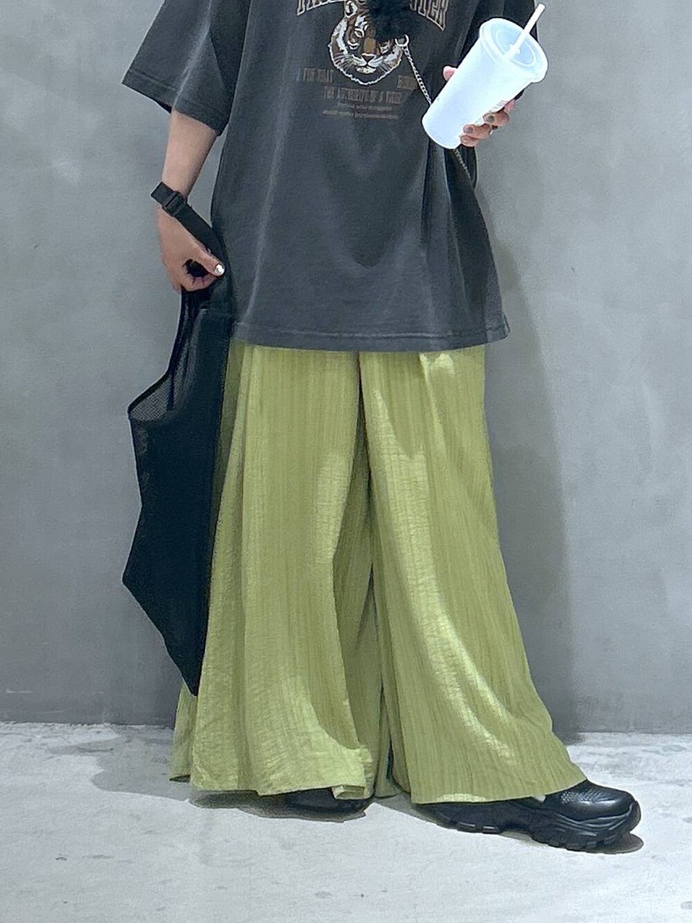 ブラック系のスニーカー、グリーン系のその他パンツ、グレー系のTシャツ/カットソーを着用したレディースの春コーディネートの6枚目の写真