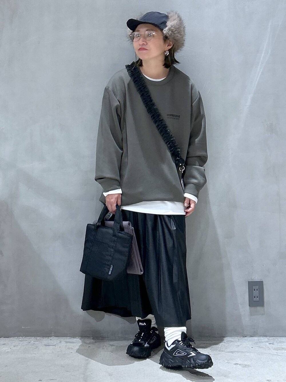 グレー系のスニーカー、ブラック系のスカート、グレー系のアウトドアグッズを着用したレディースの秋コーディネートの5枚目の写真
