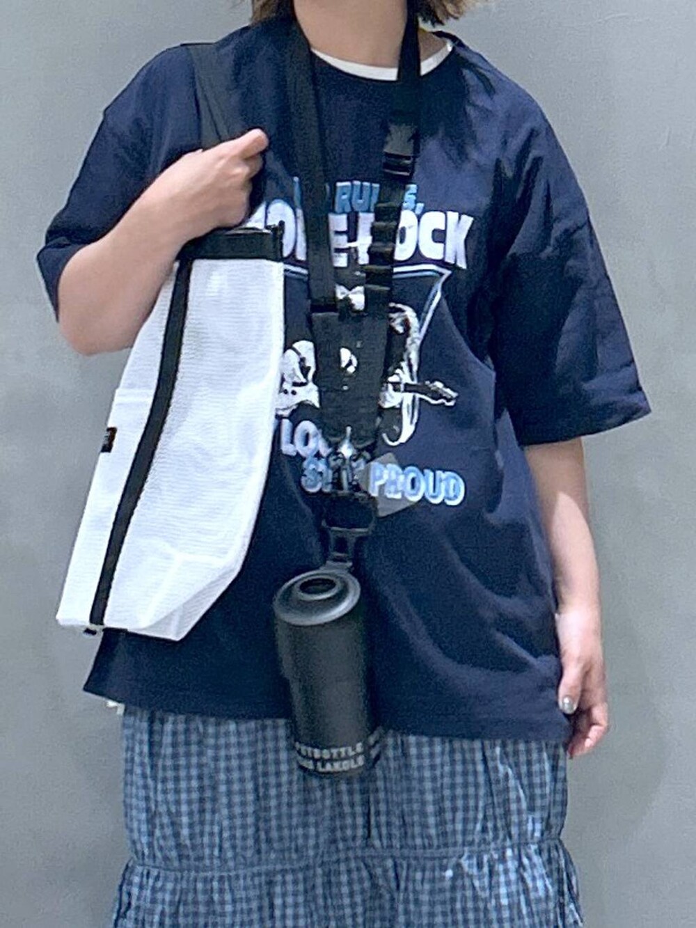 ブラック系のスニーカー、ホワイト系のTシャツ/カットソー、ブラック系のスマホグッズを着用したレディースの春コーディネートの3枚目の写真