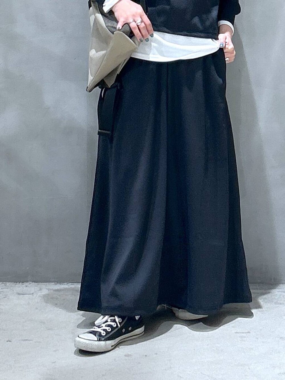 ブラック系のスカート、ブラック系のTシャツ/カットソー、ホワイト系のTシャツ/カットソーを着用したレディースの春コーディネートの4枚目の写真