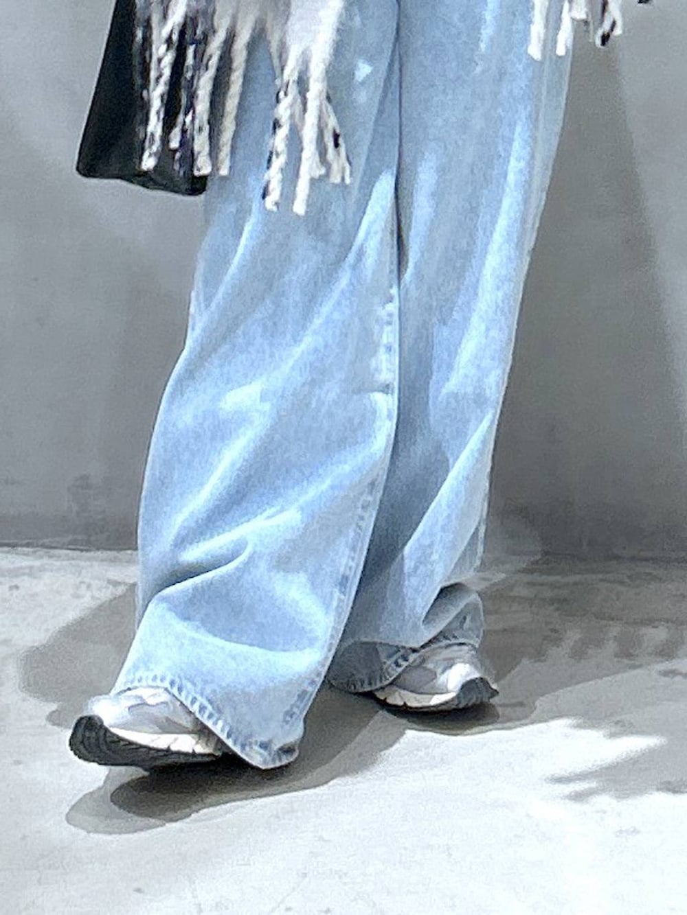 ブルー系のデニムパンツ、グリーン系のニット/セーター、ブラック系のトートバッグを着用したレディースの冬コーディネートの4枚目の写真