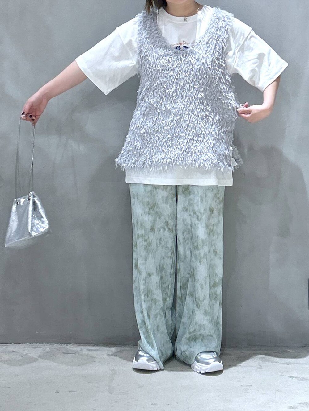 その他のショルダーバッグ、シルバー系のスニーカー、グレー系のベストを着用したレディースの春コーディネートの5枚目の写真